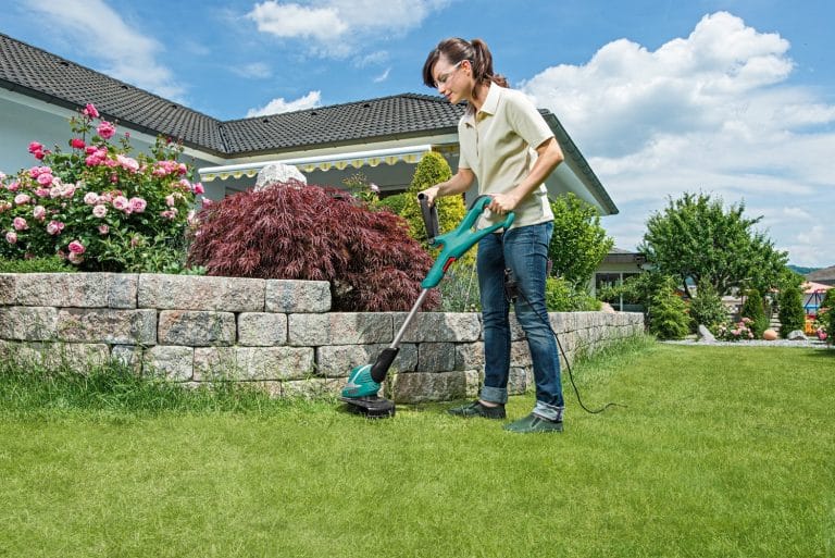 Une dame satisfaite de son coupe-bordure